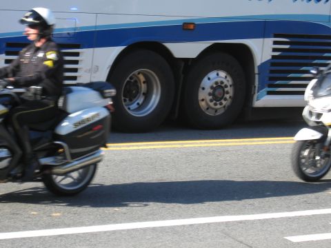 1991 Ford LTD Crown Victoria - Two white sheriff police motorcycles pass each other in the street in front of a bus's large dual rear wheels.