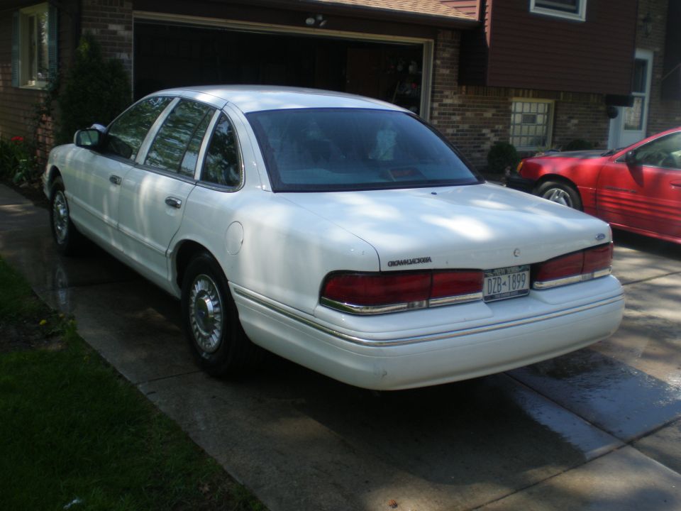 1996 Ford Crown Victoria sedan, white, parked in driveway.