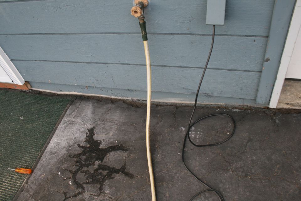 Garden hose connected to an exterior wall spigot