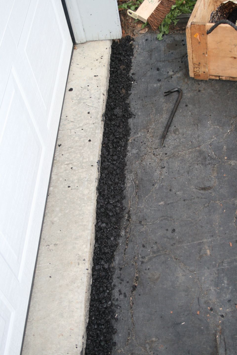 Asphalt sealant applied along a concrete threshold