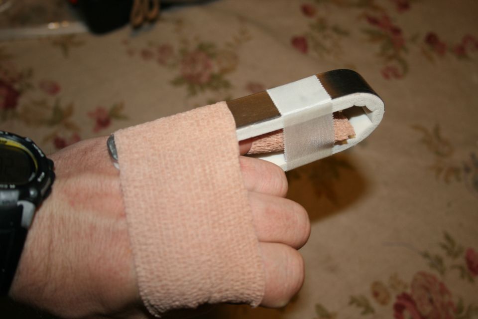Finger immobilized in a splint with bandage wrap