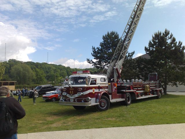 Vintage ladder fire truck with raised aerial on grass