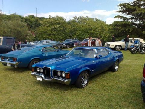 1991 Ford Crown Victoria - A blue 1971 Mercury Cougar XR-7 is parked on a grassy field at a car show.