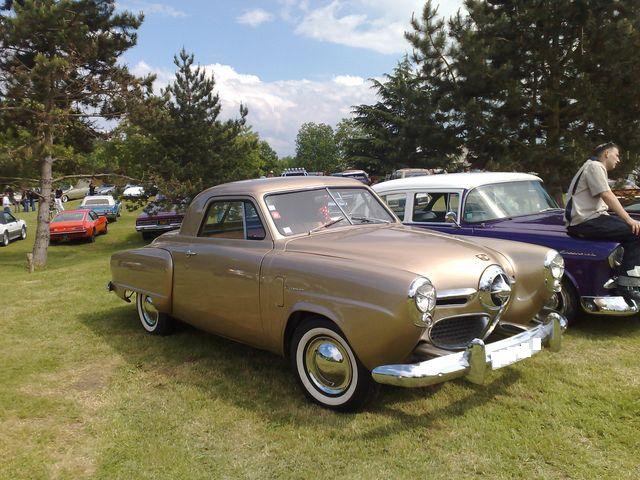 Gold coupe with chrome grille and bumper, white wall tires