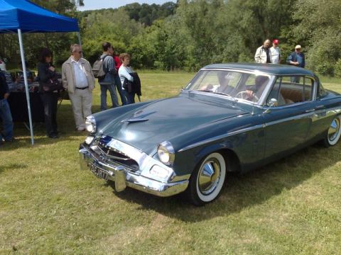 1991 Ford Crown Victoria - A 1955 Studebaker President coupe is parked on grass at an outdoor event.