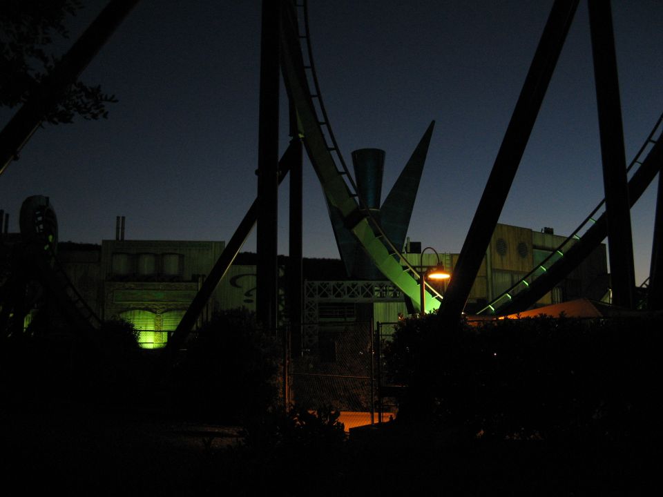 Roller coaster structure and a building at night.