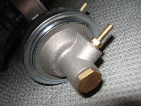 1968 Shelby GT500 - A metal fuel pressure regulator with brass fittings is shown against a textured gray background.