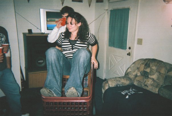 People gathered in a room, one woman sitting in a basket-like chair