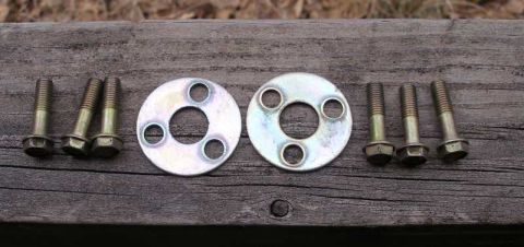 1993 Ford Taurus - Six bolts and two washers are laid out on a weathered wooden plank.