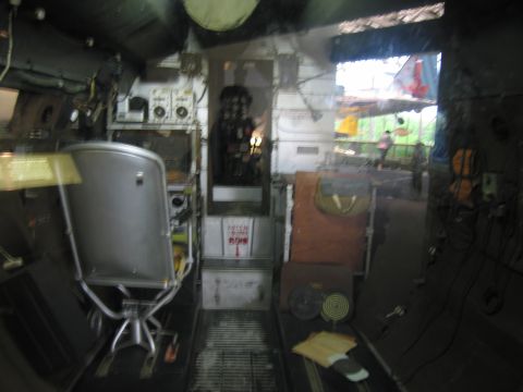 1991 Ford LTD Crown Victoria - dimly lit interior compartment, possibly of an aircraft or vessel, showing a metal swivel seat, control panels, and equipment.