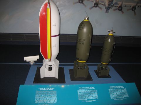 1991 Ford LTD Crown Victoria - museum display of three WWII aerial bombs of varying sizes, one striped red and yellow, on stands with explanatory placards.