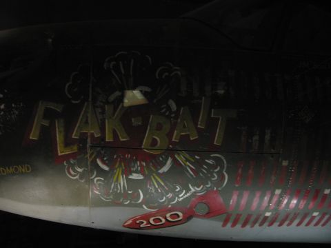 1991 Ford LTD Crown Victoria - Close-up of WWII bomber nose art lettered 'FLAK-BAIT' with rows of mission symbols and a red '200' marking.