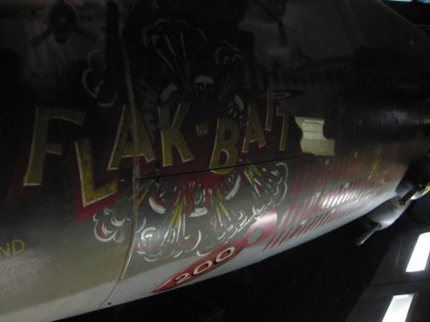 1991 Ford LTD Crown Victoria - Weathered WWII bomber nose art reading 'FLAK-BAIT' alongside painted mission tally marks and a red '200'.