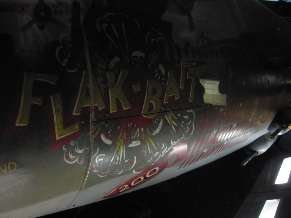 Weathered FLAK-BAIT nose art with mission tally marks on a bomber fuselage