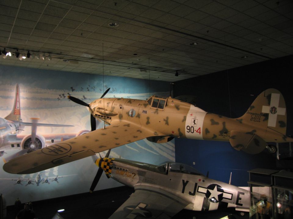 Desert-camouflage WWII fighter marked 90-4 hung over a star-marked aircraft