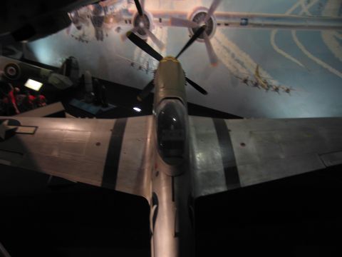 1991 Ford LTD Crown Victoria - low-angle underside view of a WWII fighter aircraft, showing its belly, wings and propeller against a painted ceiling mural.