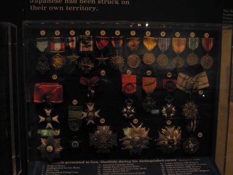 1991 Ford LTD Crown Victoria - Dozens of numbered military decorations including stars, crosses and ribbons are arranged in a dark glass museum case.