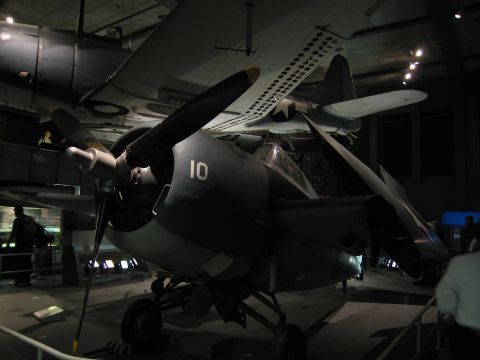 1991 Ford LTD Crown Victoria - twin-engine propeller military aircraft numbered 10 sits on display in a dimly lit museum hangar.