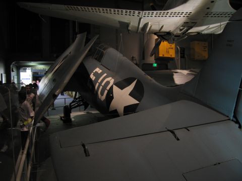 1991 Ford LTD Crown Victoria - gray Navy aircraft with a folded wing shows a white star insignia and the marking E10 in a museum exhibit.