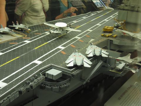 1991 Ford LTD Crown Victoria - close view of an aircraft carrier model shows model fighter jets, a radar plane and a tow tractor on the angled deck.
