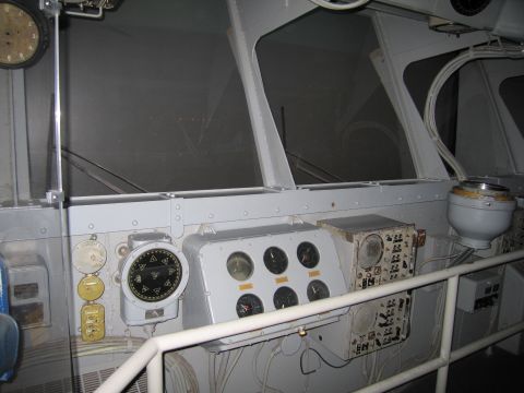 1991 Ford LTD Crown Victoria - Interior of a ship bridge with gray panels, round gauges, a gyrocompass and large windows.