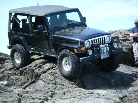 2005 Jeep Wrangler - 2005 Jeep Wrangler navigating a rocky trail with a winch mounted on the front bumper.