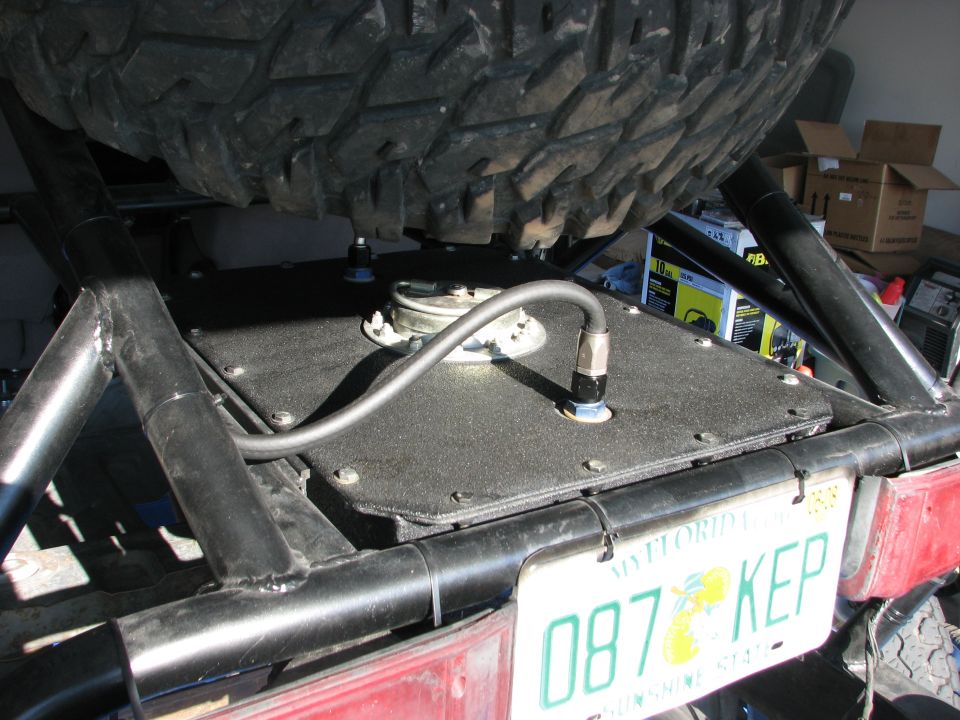 Aftermarket fuel cell installed on a vehicle frame, with a spare tire above and a Florida license plate reading 087 KEP