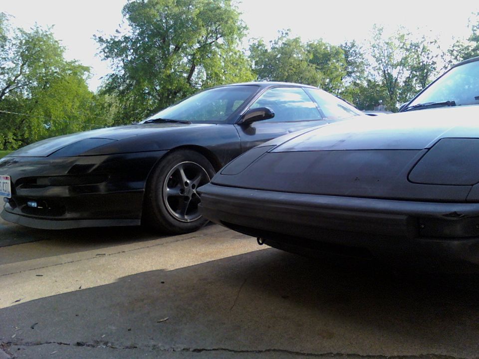 Two black coupes, one in foreground, one behind