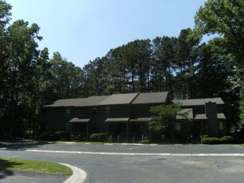 1992 Ford F-150 - Apartment buildings are surrounded by trees under a clear blue sky.
