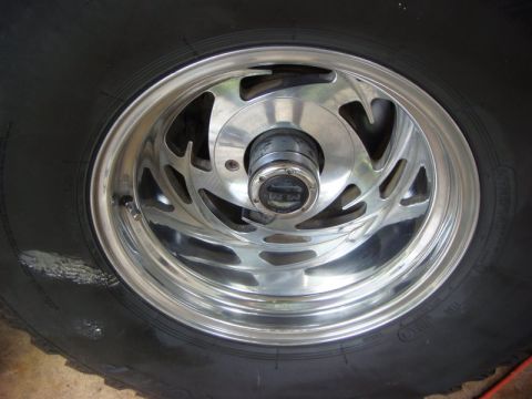 1996 Ford Bronco - A close-up view of a polished chrome wheel and black tire, a center cap with 'M/T' branding.