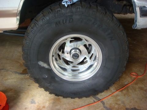 1996 Ford Bronco - The "Mud Terrain" tire and polished wheel are the focus of this close-up shot.