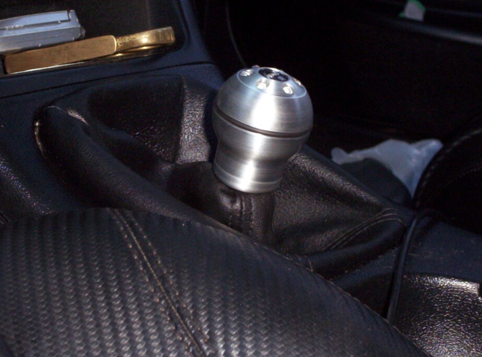 Close-up of aftermarket shift knob and carbon fiber trim