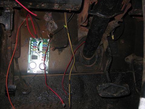 1979 Ford Bronco - A custom fuse block with multiple fuses is installed on the firewall of a vehicle, with various wires connected to it. Visible pedals for c…