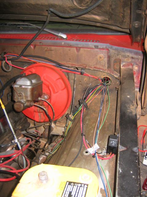 1979 Ford Bronco - The engine bay of a red Ford Bronco shows a red brake booster and master cylinder assembly with various wiring harnesses routed through the…