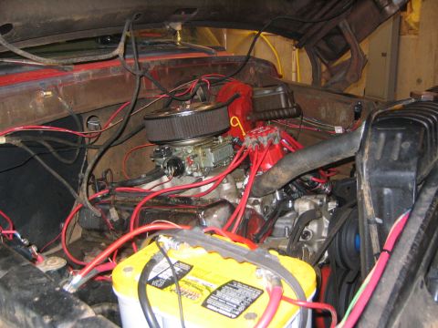 1979 Ford Bronco - The engine bay of a classic Ford Bronco, featuring a V8 engine with a chrome air cleaner, red spark plug wires, and a yellow Optima battery…