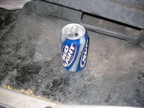 1979 Ford Bronco - A single Bud Light can sits on a dark, textured surface, possibly the floor of a vehicle. The can is mostly blue and silver with white lett…