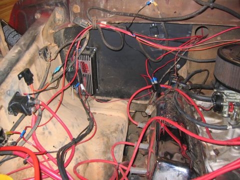 1979 Ford Bronco - The engine bay of a classic Ford Bronco shows a complex wiring harness connected to various components, including a black ignition module w…