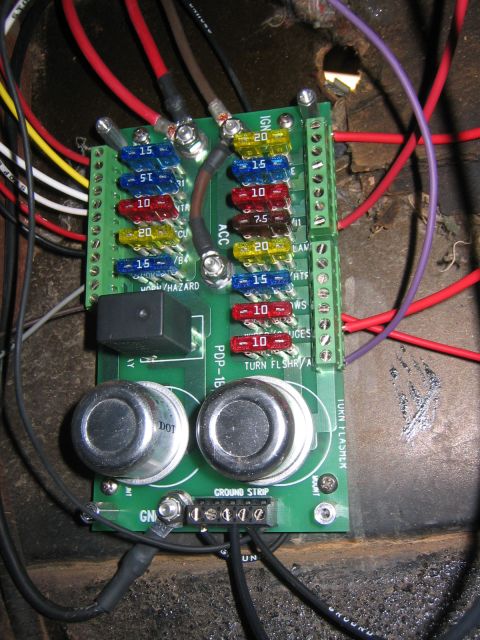 1979 Ford Bronco - A close-up view of a vehicle's wiring harness, a fuse block and relays.