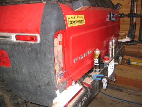 1979 Ford Bronco - The rear passenger side of a red Ford Bronco is shown, with the taillight removed and wiring exposed. A license plate is attached to the re…