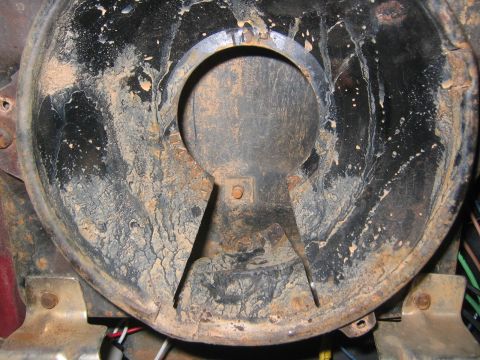 1979 Ford Bronco - This is a close-up view of the dirty and corroded interior of a black metal component, likely part of a vehicle's engine bay or undercarria…