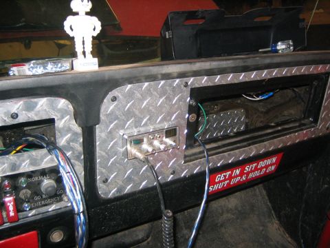 1979 Ford Bronco - The interior of a vehicle shows a custom dashboard with diamond plate accents. Visible components include a CB radio, various switches, and…