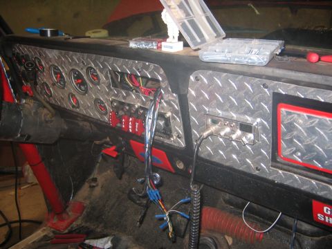 1979 Ford Bronco - The interior of a vehicle shows a custom diamond plate dashboard with multiple gauges, switches, and a CB radio. Wiring is visible, indicat…