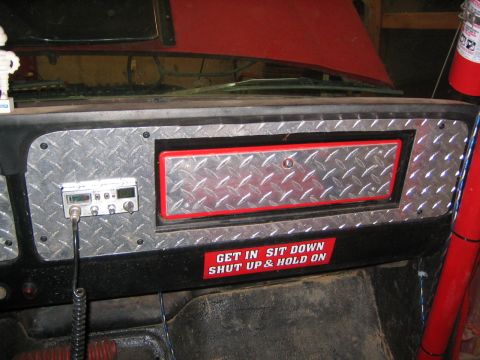 1979 Ford Bronco - The interior dashboard of a vehicle features a CB radio mounted on a diamond plate panel. A red and white sticker below reads "GET IN SIT D…