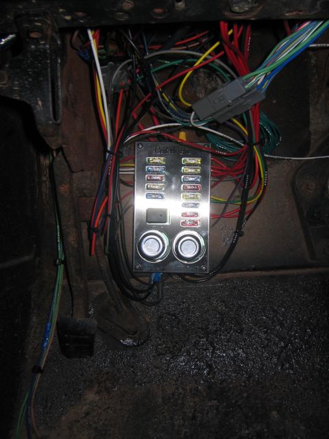 1979 Ford Bronco - A close-up view of a custom fuse block and wiring harness installed under the dashboard of a vehicle, likely a 1979 Ford Bronco, featuring…