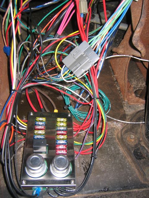 1979 Ford Bronco - A close-up view of a custom wiring harness and fuse box installed in a vehicle. The fuse box is labeled "Centech, Inc." and contains multip…