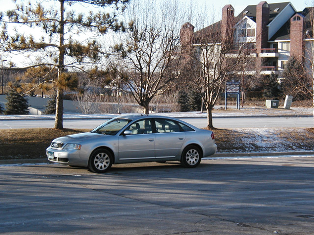 Silver Audi A6 sedan, side view, parked outdoors in winter