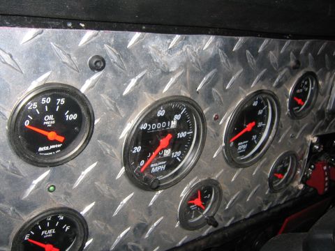 1979 Ford Bronco - A close-up view of a diamond plate dashboard featuring multiple Auto Meter gauges including oil pressure, RPM, speedometer, fuel level, and…