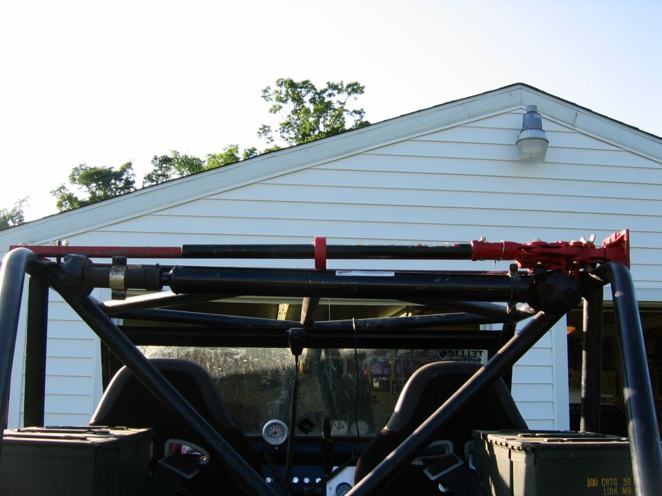High-lift jack mounted on a vehicle roll cage