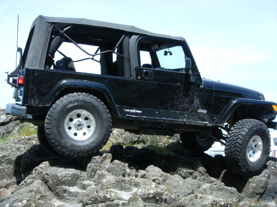 Black Jeep Wrangler off-roading on rocks