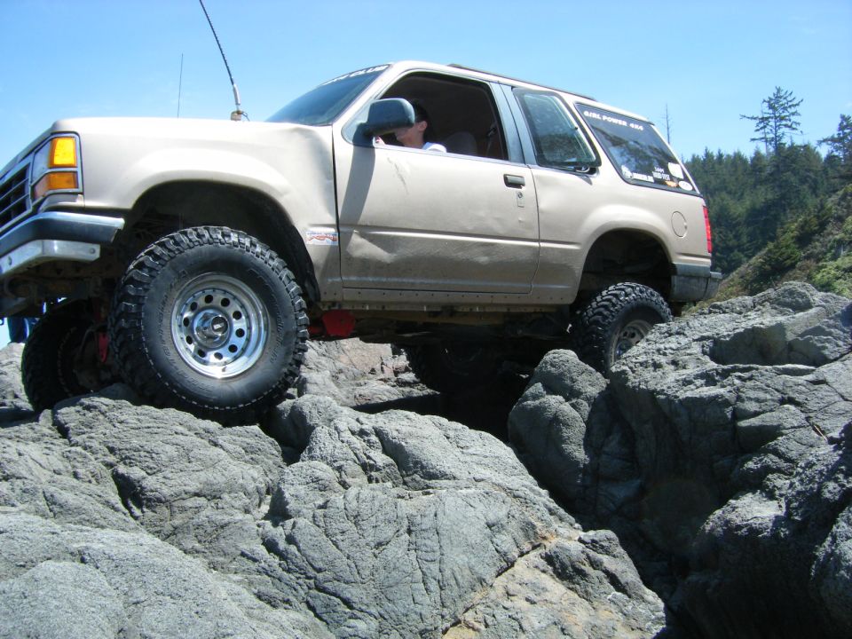 Tan 1994 Ford Explorer off-roading over rocks